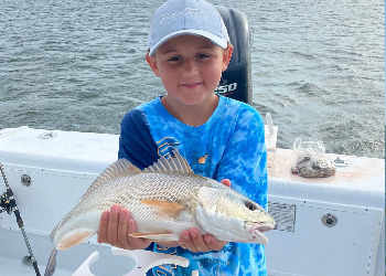 Young angler showing his pride in catching nice red drum.